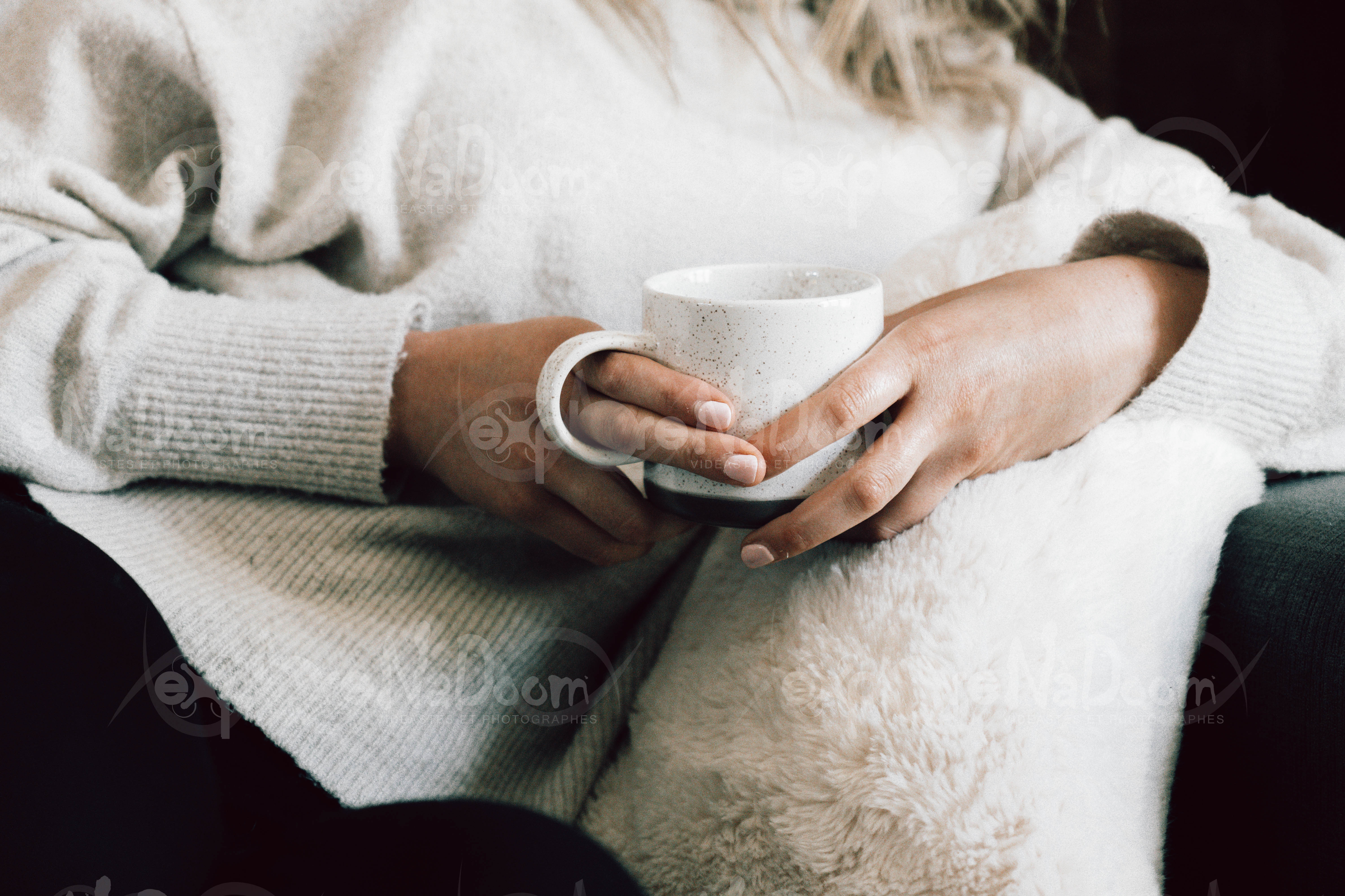 Femme assise dans un divan qui tien un café – 2